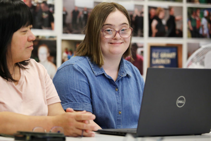 Photo of a young person with Down syndrome using a laptop.